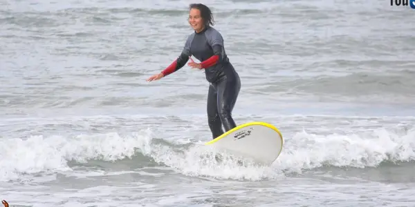 Surfeuse debout dans l'écume