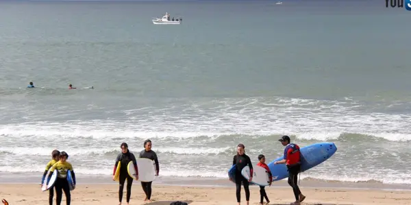 Le groupe part vers l'eau, planches à la main