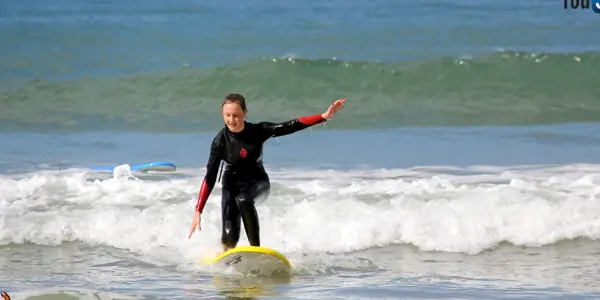 Surfeuse qui glisse sur une petite vague