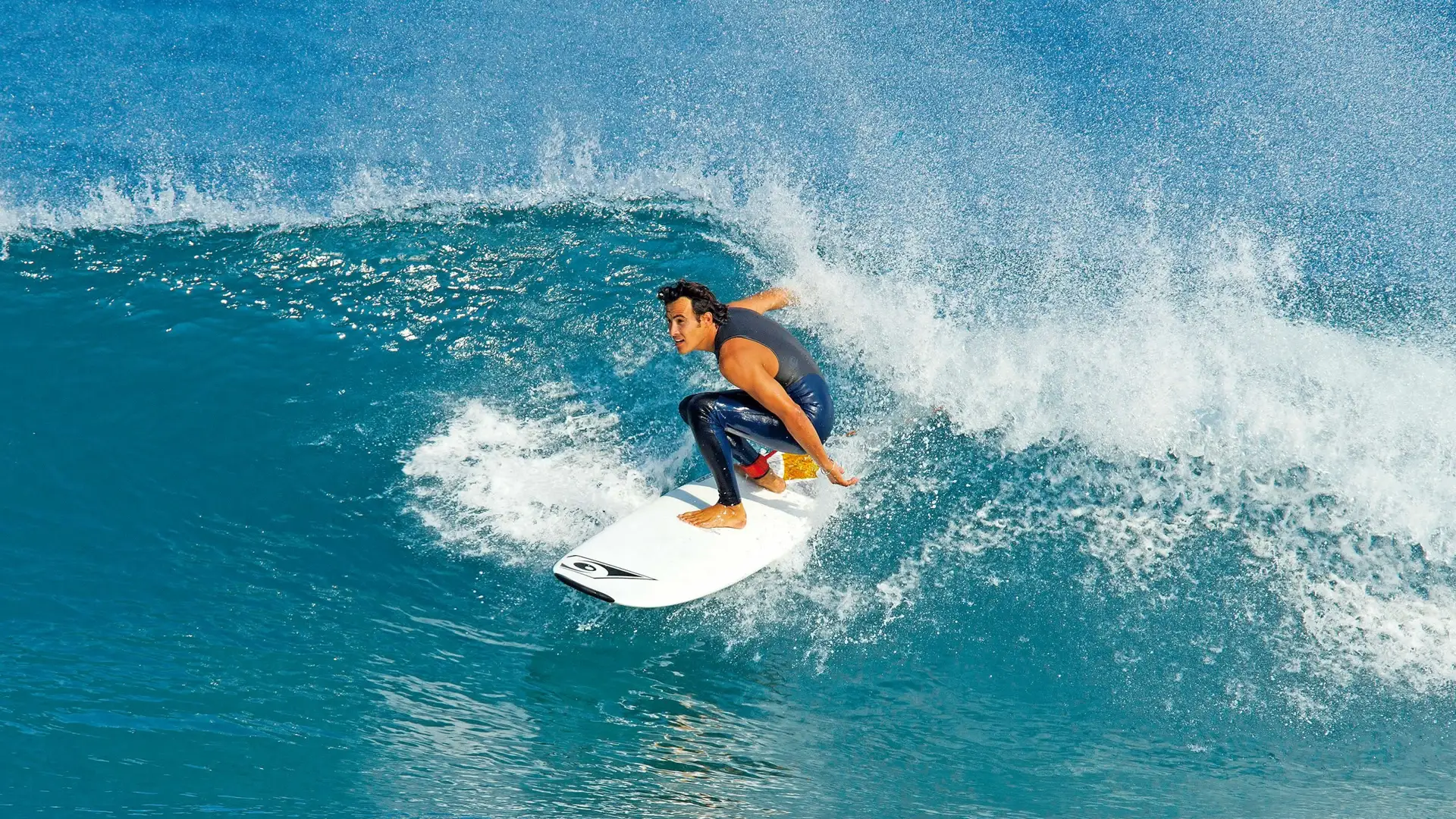 Un surfeur prend une vague bleue